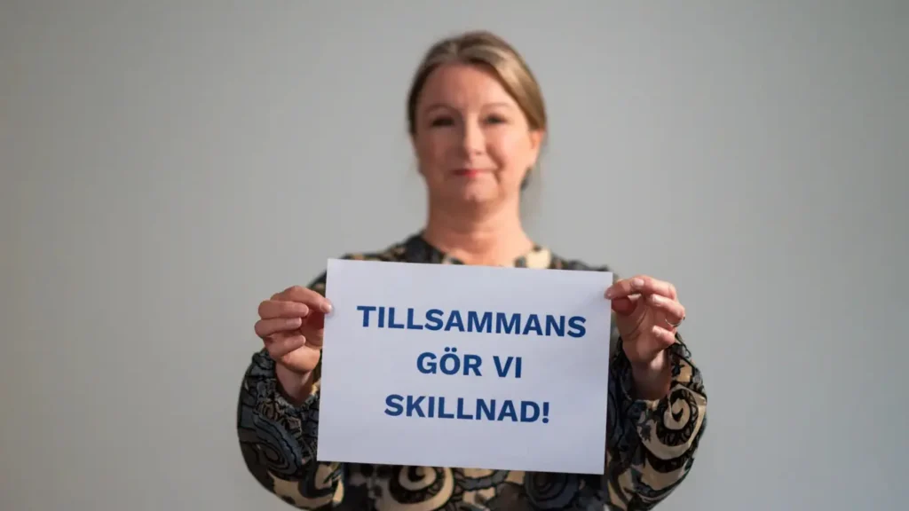 Person som håller skylt "Tillsammans gör vi skillnad"