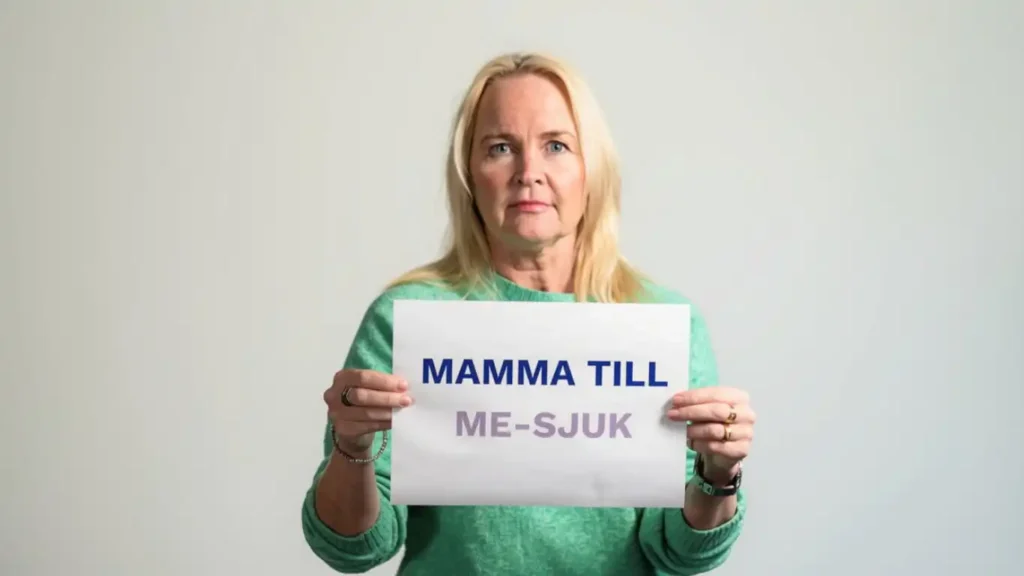 Kvinna med skylten "Mamma till ME-sjuk"